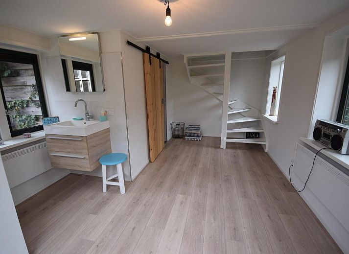 Hoelzerner Picknicktisch im Garten des Ferienhauses VZ1158 in Oostkapelle, Walcheren, umgeben von Gruenflaechen.