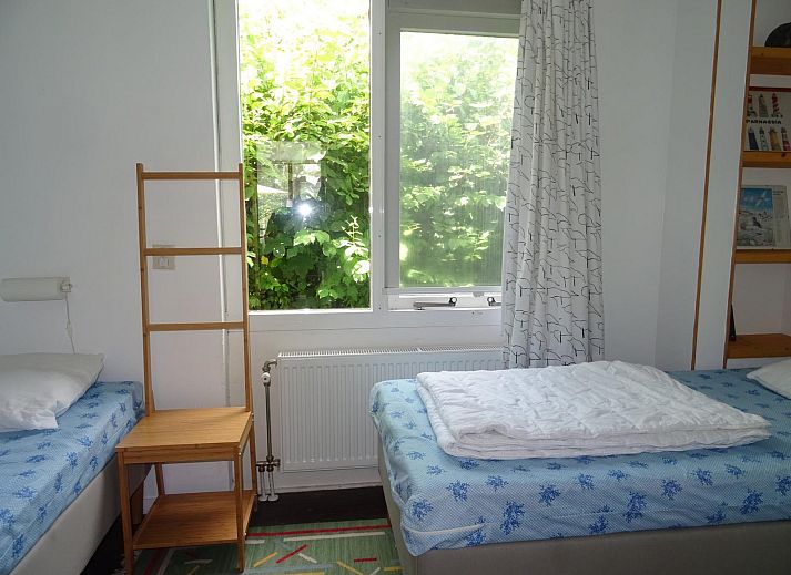 Lichte woonkamer in VZ1184 Vakantiebungalow, Oostkapelle, met uitzicht op de tuin in Walcheren, Zeeland.