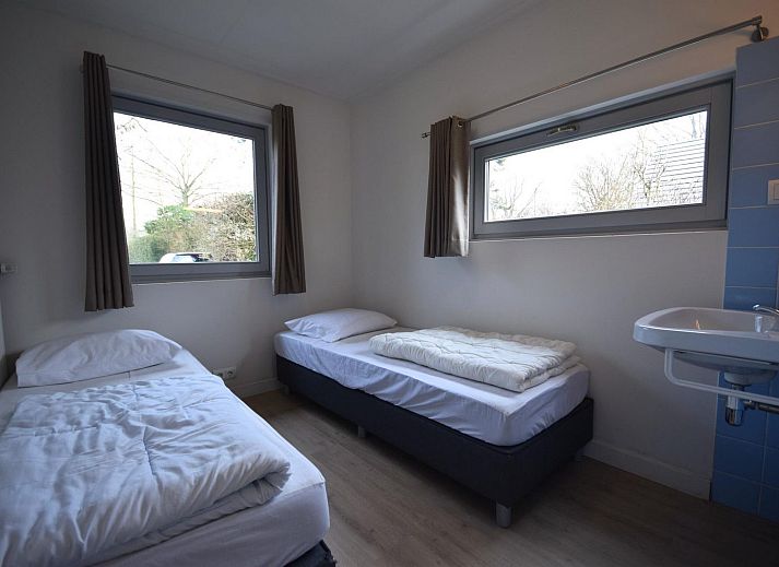 VZ1169 Ferienbungalow in Oostkapelle mit gepflastertem Innenhof und gruenen Hecken.