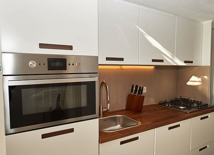 Modernes Wohnzimmer mit offener Kueche im Ferienhaus in Oostkapelle, Walcheren, Zeeland.