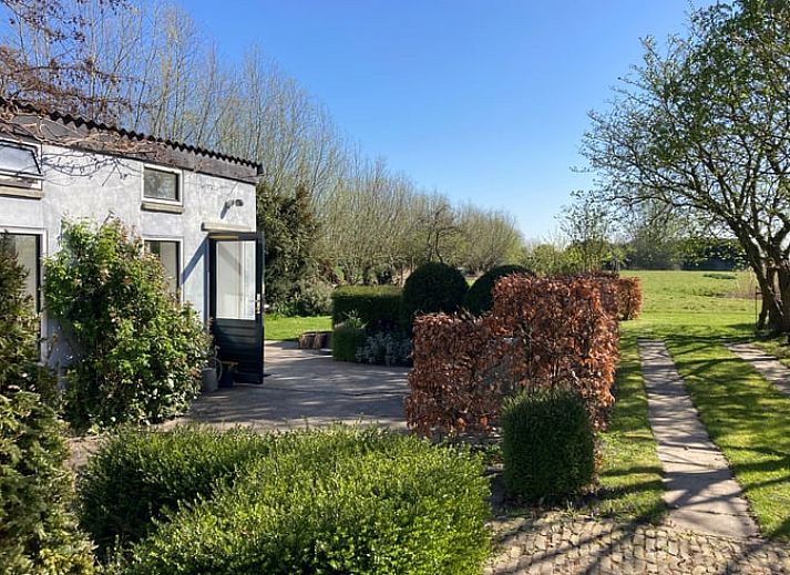Huisje in Oostkapelle omringd door bomen in Walcheren, Zeeland.