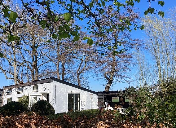 Huisje in Oostkapelle omringd door bomen in Walcheren, Zeeland.