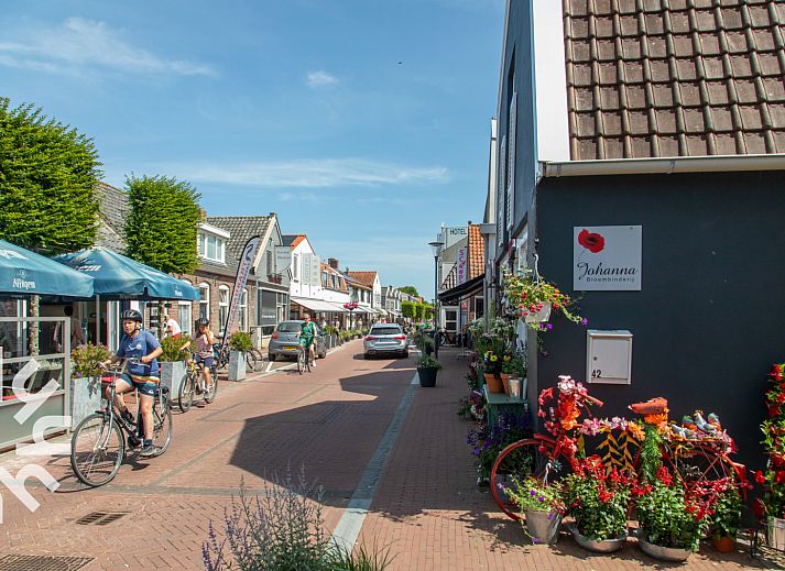 Veranda of vacation home ZE721 in Oostkapelle, Walcheren, with garden furniture and parasol.