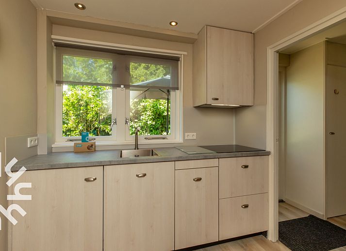 Veranda of vacation home ZE721 in Oostkapelle, Walcheren, with garden furniture and parasol.