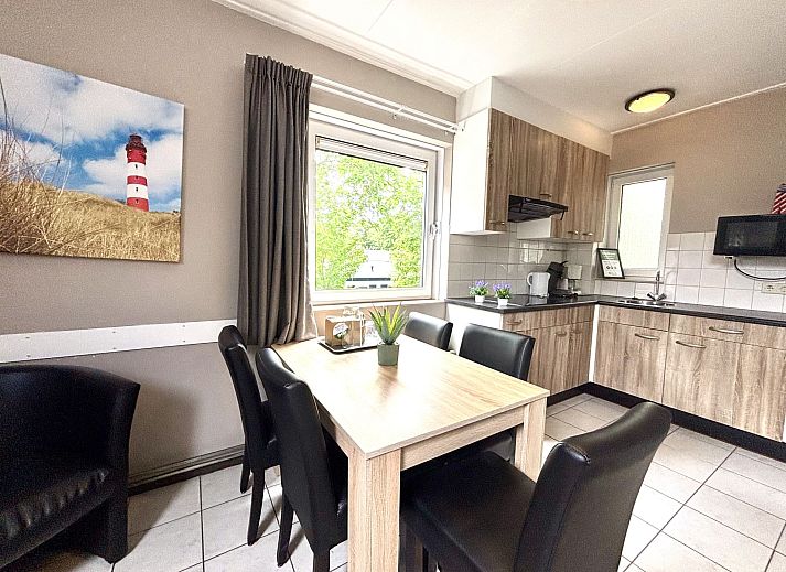 Gezellige eetruimte in Appartement Boszicht 3 in Oostkapelle, Walcheren, Zeeland met uitzicht op natuur.