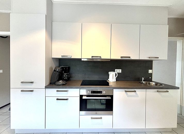 Vooraanzicht van Vakantiehuis Boszicht 2 in Oostkapelle, Walcheren, met groene omgeving.