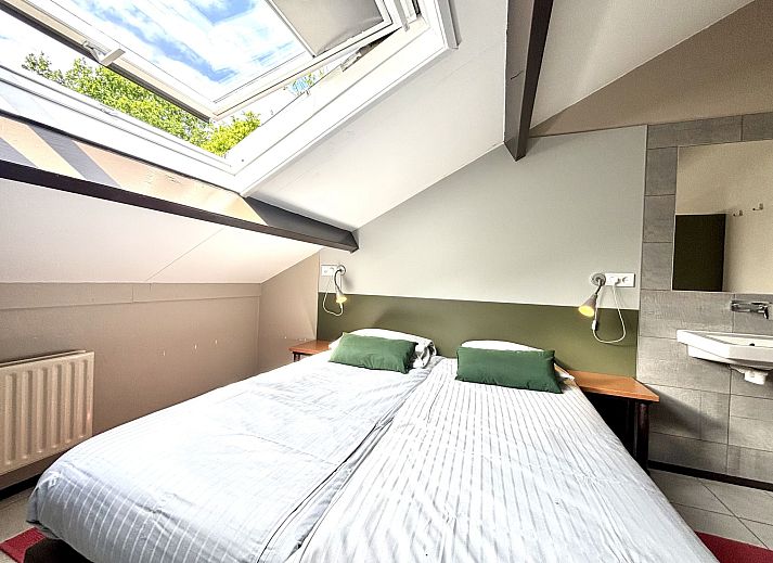 Balkon van Appartement Boszicht 4 in Oostkapelle, Walcheren, Zeeland met uitzicht op groene tuin.