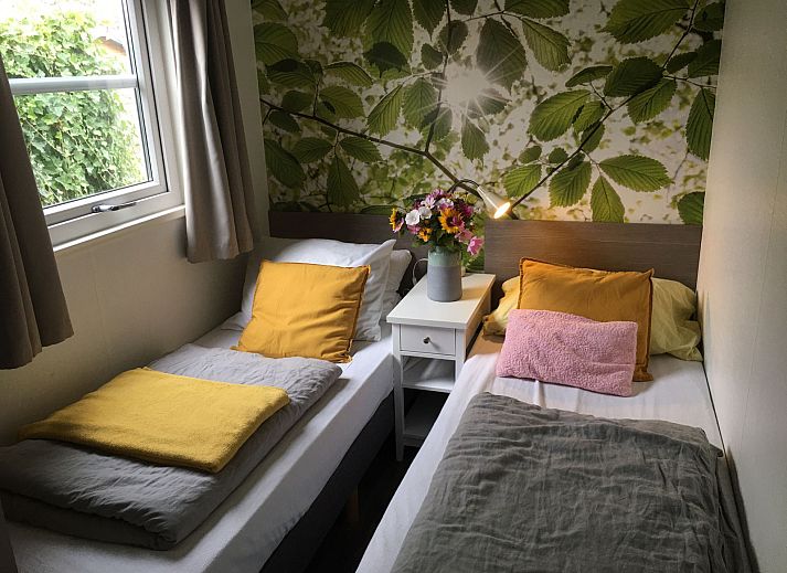 Gezellige slaapkamer in ZE1593 vakantiehuis Oostkapelle, Walcheren, met tweepersoonsbed en bloemen.