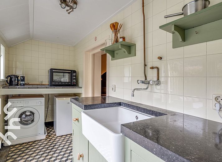 Aussenansicht des Ferienhauses ZE049 in Oostkapelle, Walcheren, Zeeland mit gruener Umgebung.