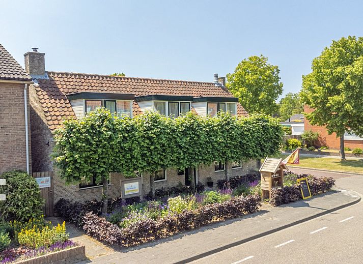 Vorderansicht des Ferienhauses ZE049 in Oostkapelle, Walcheren, Zeeland mit bluehendem Garten.