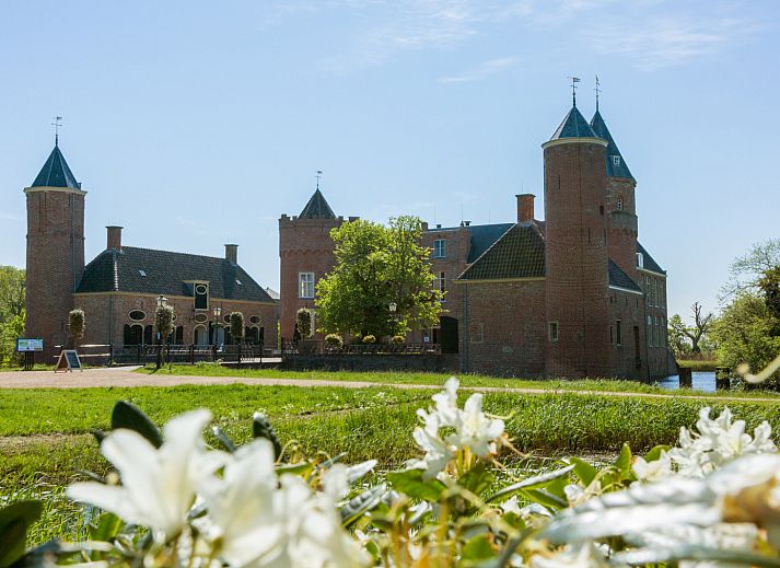 Gezellige zithoek in vakantiehuis ZE1678, Oostkapelle, Walcheren, met kunst aan de muur en uitzicht op de tuin in Zeeland.