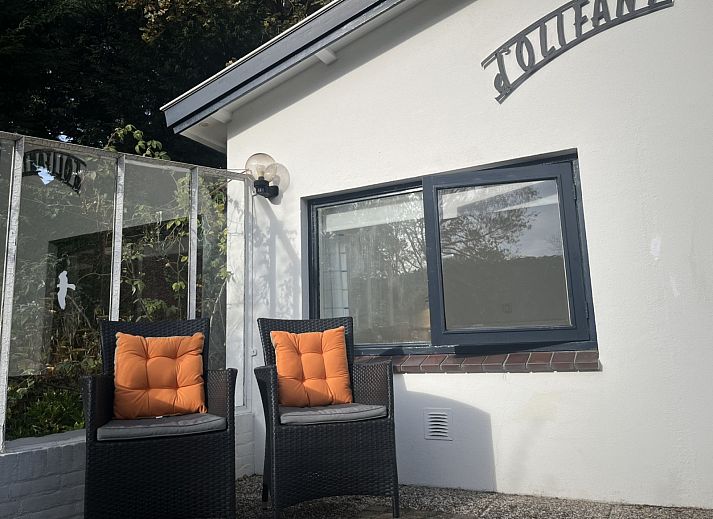 Gezellige zithoek in vakantiehuis ZE1678, Oostkapelle, Walcheren, met kunst aan de muur en uitzicht op de tuin in Zeeland.