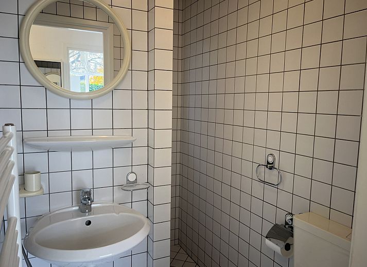 Gezellige zithoek in vakantiehuis ZE1678, Oostkapelle, Walcheren, met kunst aan de muur en uitzicht op de tuin in Zeeland.