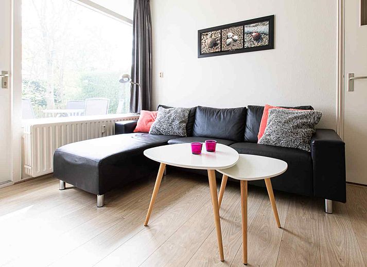 Ferienhaus ZE069 in Oostkapelle mit bluehenden Baeumen und gruener Umgebung in Zeeland.