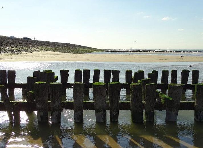Strand in der Naehe des Ferienhauses ZE069 in Oostkapelle, Walcheren, mit weitem Sand und blauen Wellen.