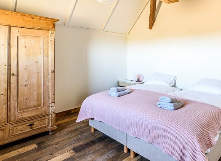 Strand in de buurt van Hoeve Plantlust, Oostkapelle, met houten palen en uitzicht op de zee.