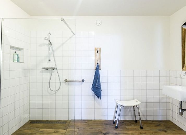 Strand in de buurt van Hoeve Plantlust, Oostkapelle, met houten palen en uitzicht op de zee.