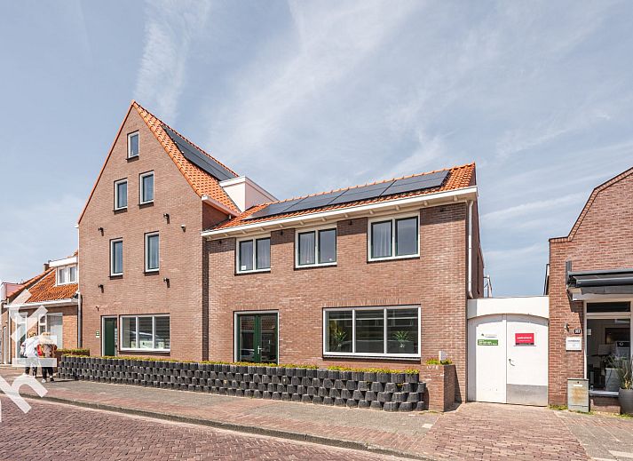 Exterior of vacation home ZE1315 in Westkapelle, Walcheren, Zeeland with red roofs and sunny street.