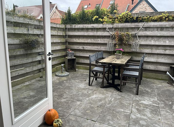 Gezellige eetkamer in vakantiehuis ZE1677, Domburg, Walcheren, met uitzicht op zonnig terras en stijlvolle rieten stoelen in Zeeland.