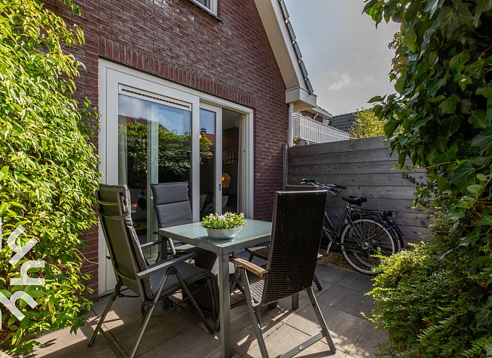 Gezellig terras van vakantiehuis ZE1594 in Domburg, Walcheren, Zeeland met groene planten en eettafel.