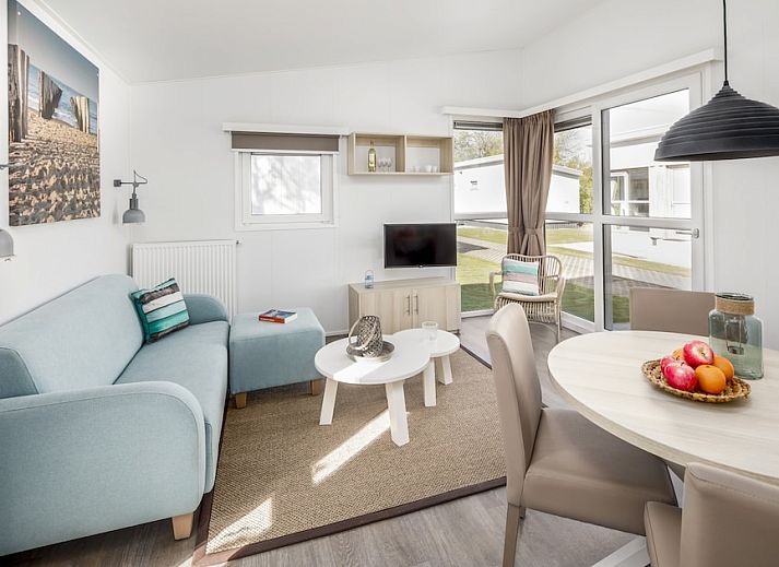 Gezellige woonkamer in L4A Comfort vakantiehuis Domburg, Walcheren, Zeeland met licht interieur en comfortabele zitruimte.