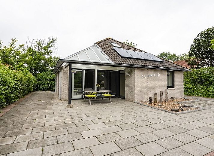 Lichte woonkamer van Westduin 4 in Vlissingen, met uitzicht op de tuin en moderne inrichting, Walcheren, Zeeland.
