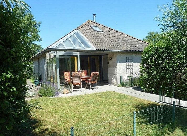 Veranda von VZ1123 Ferienhaus in Vlissingen, Walcheren, Zeeland mit Gartenmoebeln und gruener Umgebung.