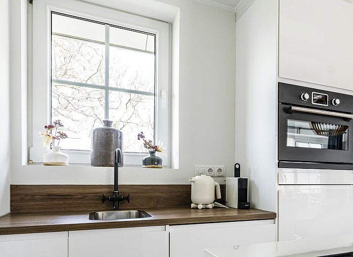 Buitenzijde van VZ1098 Vrijstaand vakantiehuis in Vlissingen, Walcheren, omringd door groen.