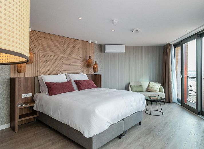 Geraeumiges Schlafzimmer in der VZ915 Deluxe Ocean Suite in Vlissingen mit Meerblick.