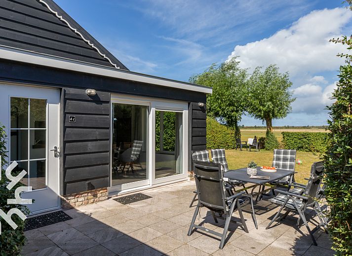 Terrasse des Ferienhauses ZE257 in Aagtekerke, Walcheren, Zeeland mit Blick auf einen gruenen Garten.