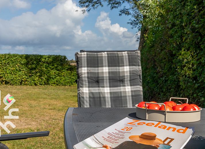 Geraeumiges Esszimmer im Ferienhaus ZE257 in Aagtekerke, Walcheren, Zeeland mit Blick auf den Garten.