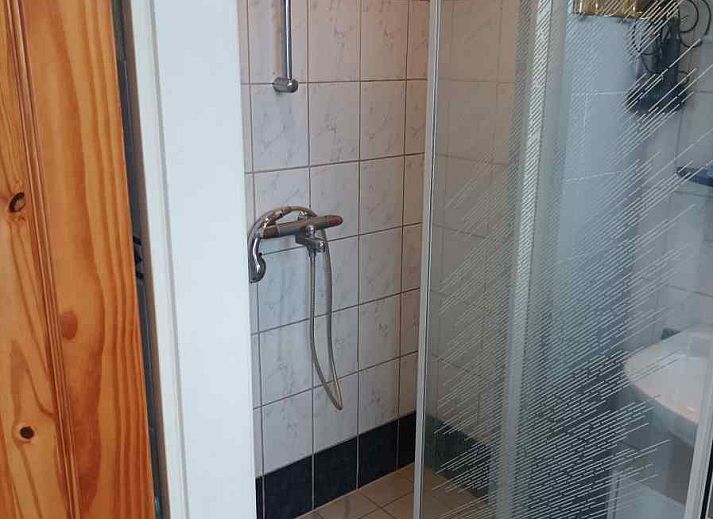 Charmantes Ferienhaus ZE555 in Aagtekerke, Walcheren mit Holzfassade und blauem Himmel.