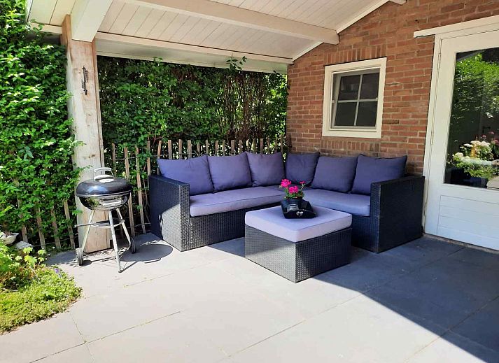 Geraeumige Terrasse am Ferienhaus ZE267 in Zoutelande, Walcheren, mit Sitzgelegenheiten und Grill fuer Spass im Freien.