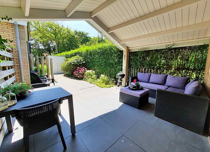 Geraeumige Terrasse am Ferienhaus ZE267 in Zoutelande, Walcheren, mit Sitzgelegenheiten und Grill fuer Spass im Freien.
