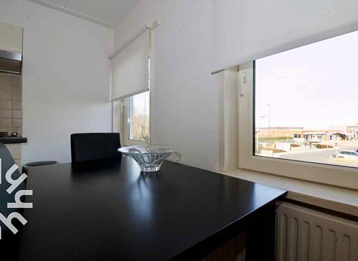 Front of vacation home ZE303 in Zoutelande, Walcheren, with flowering roses on the terrace.