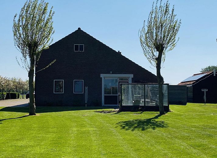 Moderne woonkamer van VZ178 Vakantiehuis Zoutelande met veel lichtinval.