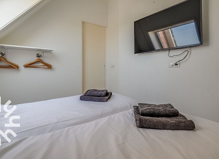 Terrasse des Ferienhauses ZE1135 in Zoutelande, Walcheren, mit bequemen Stuehlen und Tisch fuer Mahlzeiten im Freien.