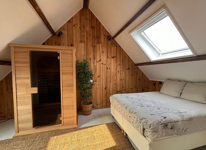 Rustieke buitenkant van Vakantiehuis in Arnemuiden, Walcheren, Zeeland met stenen muren en bloeiende planten.