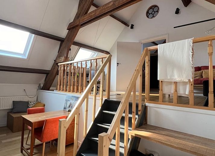 Rustieke buitenkant van Vakantiehuis in Arnemuiden, Walcheren, Zeeland met stenen muren en bloeiende planten.