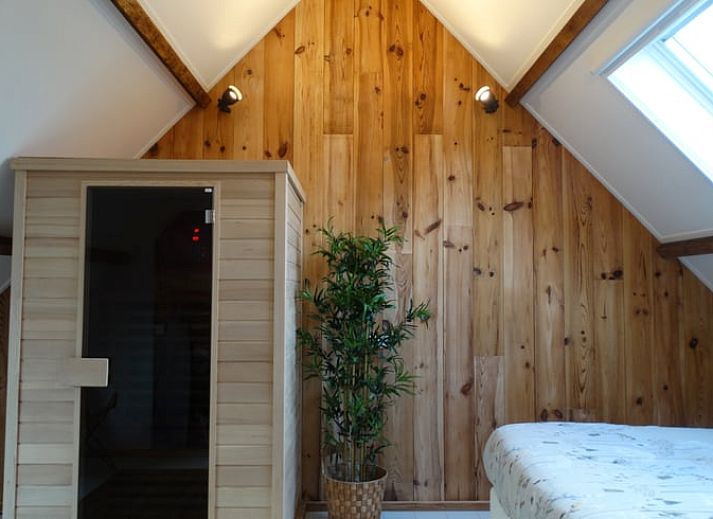 Gezellige slaapkamer in Vakantiehuis in Arnemuiden, Walcheren, Zeeland met houten wanden en dakraam.