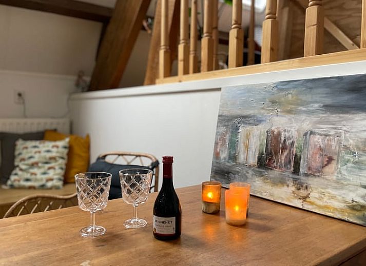 Charmant terras bij Vakantiehuis in Arnemuiden, Walcheren, Zeeland met groene klimop en houten stoelen.