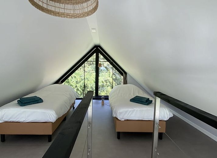 Slaapkamer met grote ramen in Vakantiehuis in Vrouwenpolder, Walcheren, Zeeland.