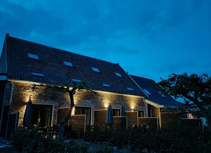 Gemuetliches Wohnzimmer im Ferienhaus in Veere, Walcheren, Zeeland mit Gartenblick und bequemer Sitzecke.