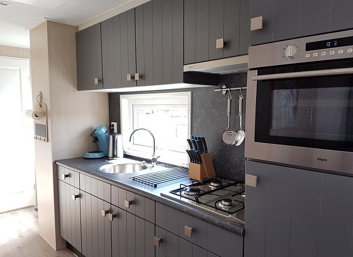 Terrasse von VZ816 Chalet in Veere, Serooskerke, Walcheren, mit Picknicktisch und Sonnenschirm.