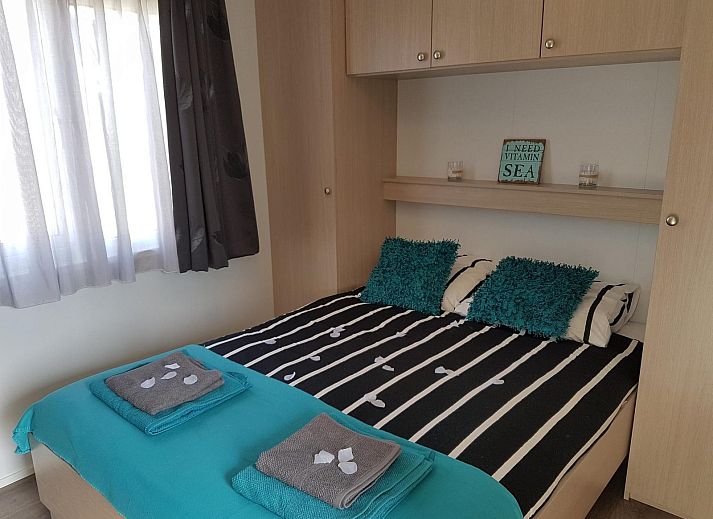 Terrasse von VZ816 Chalet in Veere, Serooskerke, Walcheren, mit Picknicktisch und Sonnenschirm.