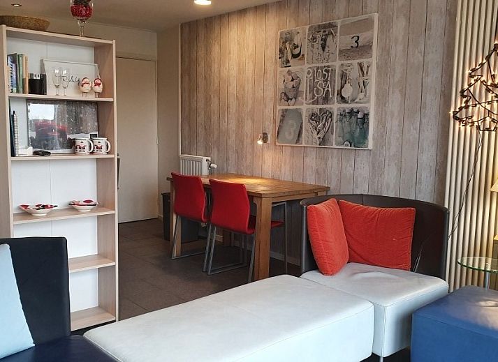 Gemuetliche Terrasse am Ferienhaus THE SUN IN STEE ON ZEE in Serooskerke, Walcheren, mit bequemen Sitzgelegenheiten und Blumen.