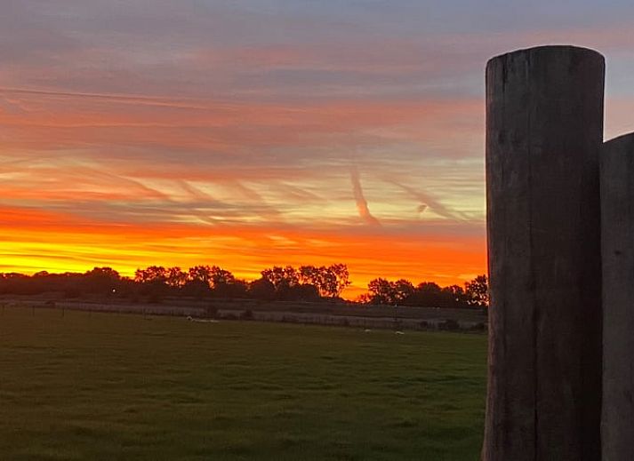 Moderne keuken in Huisje in Middelburg, een vakantiehuis in Walcheren, Zeeland, met groene kasten en een stijlvol zwart aanrecht.