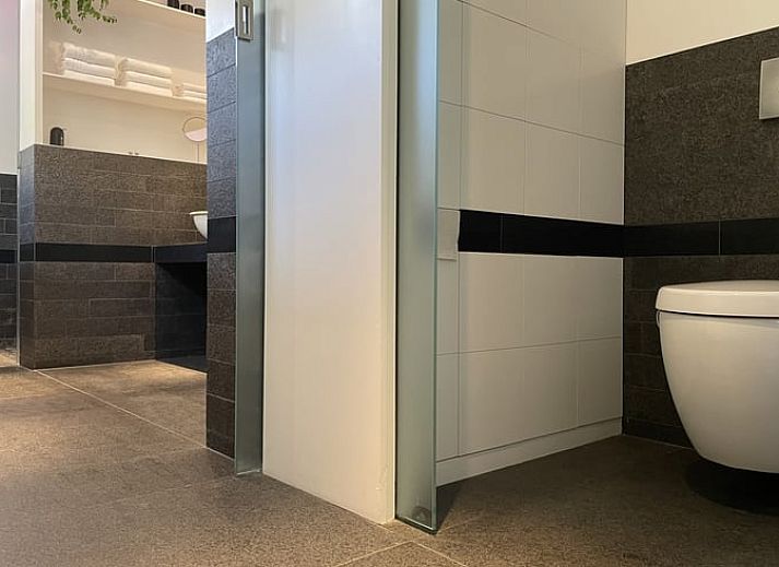 Groene tuin met hangmat en kip bij Vakantiehuisje in Biggekerke, Walcheren, Zeeland.