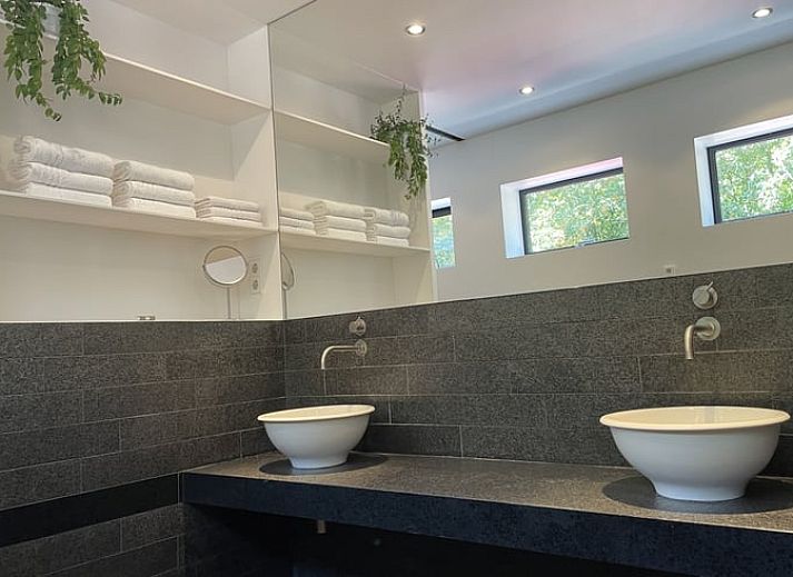 Groene tuin met hangmat en kip bij Vakantiehuisje in Biggekerke, Walcheren, Zeeland.