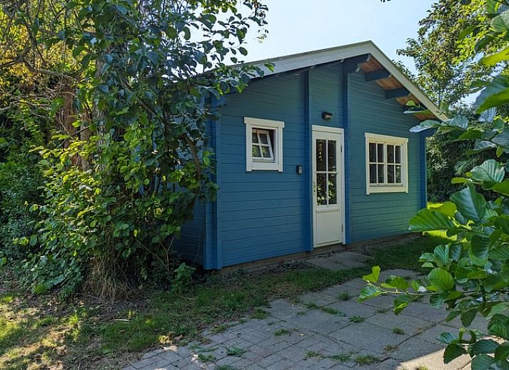 Vakantiehuisje in Oudelande met veranda omgeven door groen in Walcheren, Zeeland.